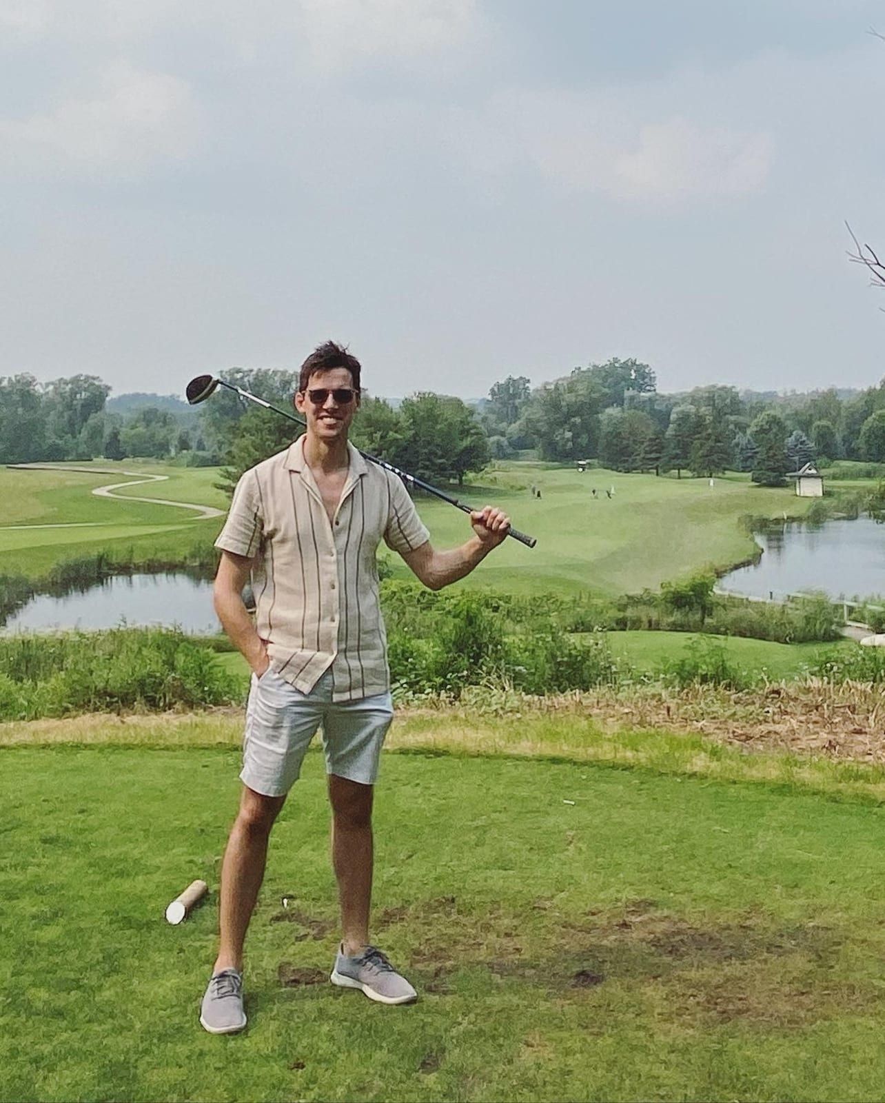 A member of Proto’s team on a tee box with a driver over their shoulder